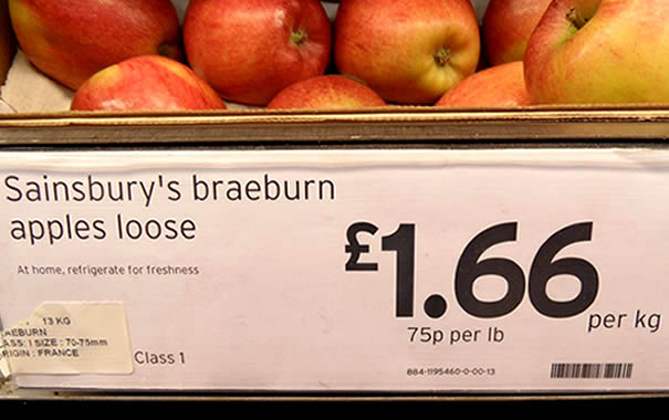 Manzanas a la venta en Sainsbury's mostrando el precio por kilo y por libra